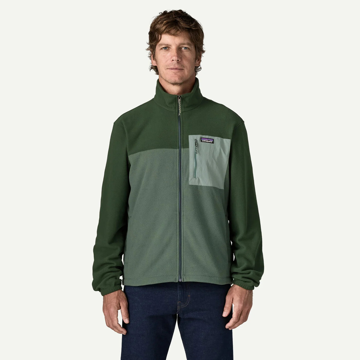 Man wearing a green jacket with a visible brand logo on a white background