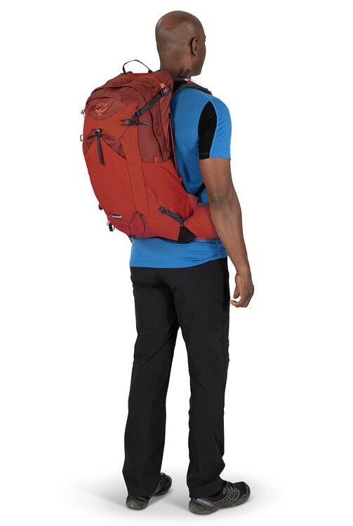 a photo of the osprey manta 24 pack in the color oak leaf orange, view on a model from behind