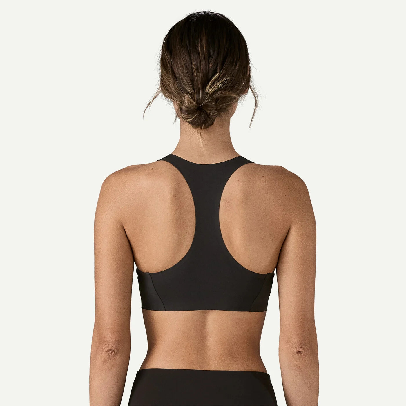 Person wearing a black sports bra on a white background