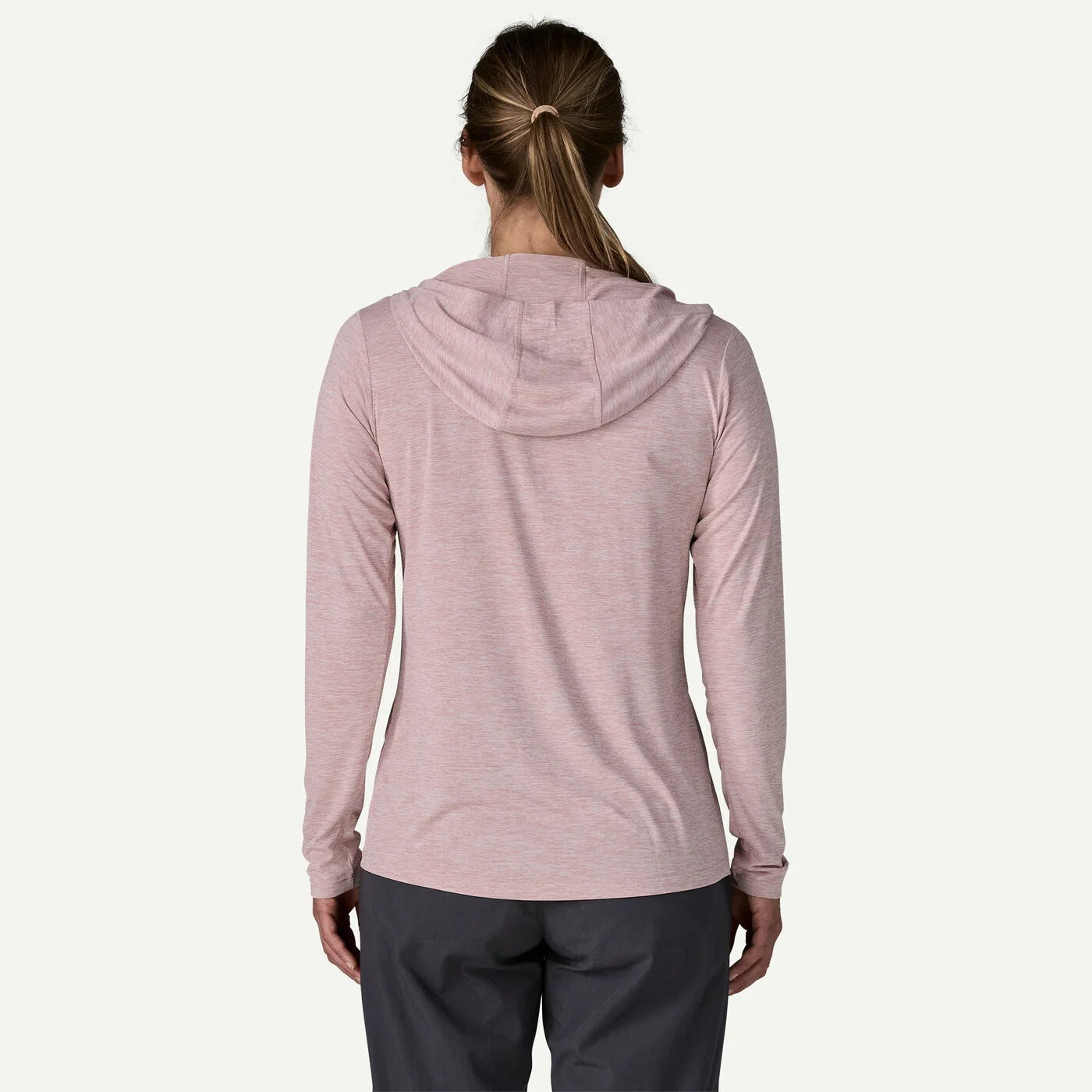 Person wearing a light pink hoodie on a white background