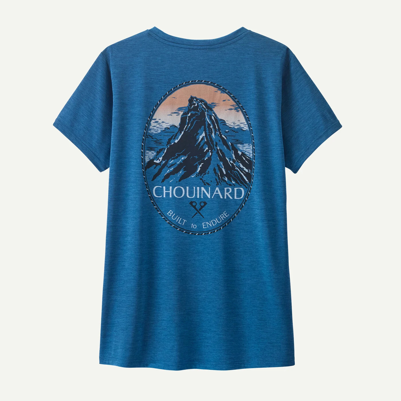 Blue t-shirt with mountain graphic and 'Chouinard' branding on a light gray background