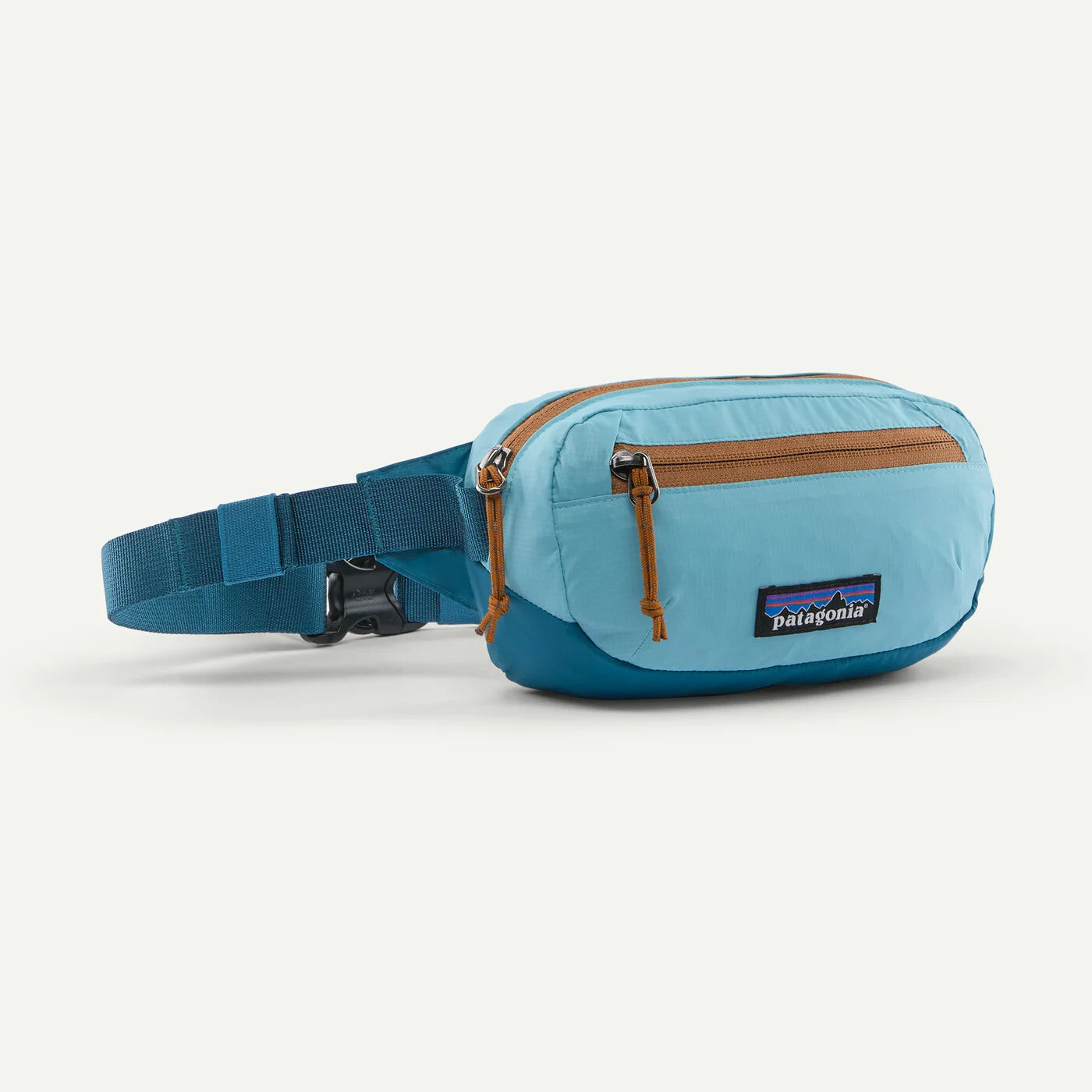 A light blue and teal Patagonia waist bag with brown zipper pulls and a matching teal adjustable strap, shown on a clean off-white background.