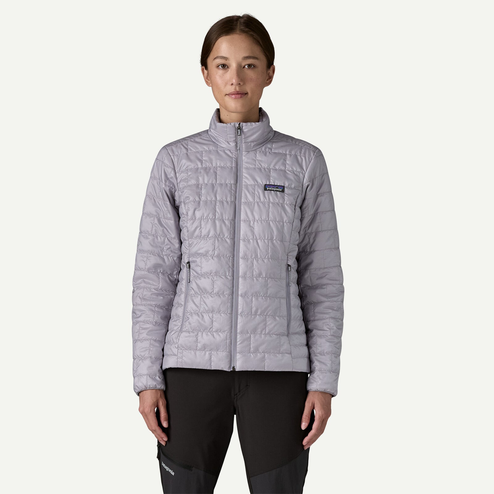 Person wearing a light purple insulated jacket with a visible Patagonia logo on a white background