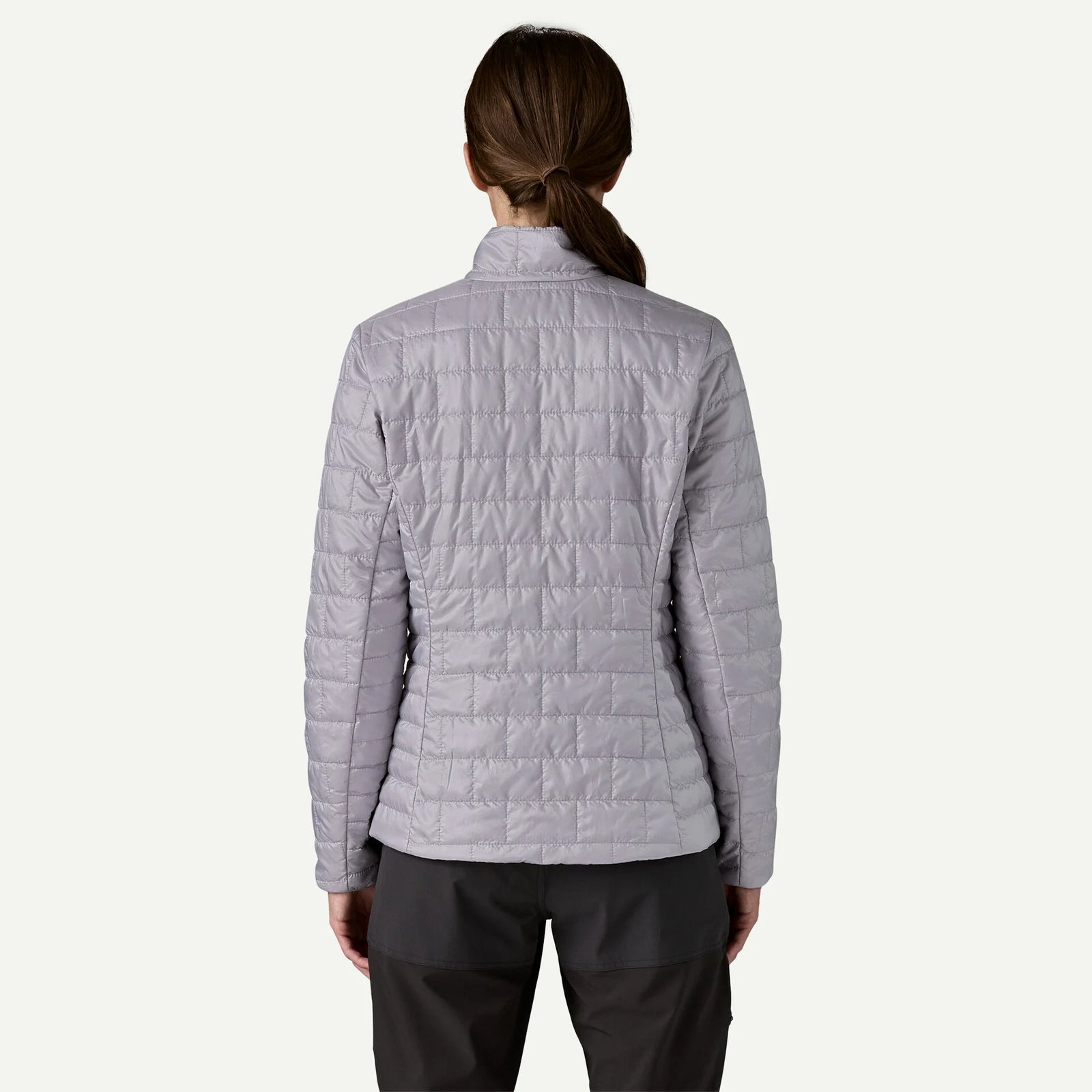 Person wearing a light purple quilted jacket on a white background