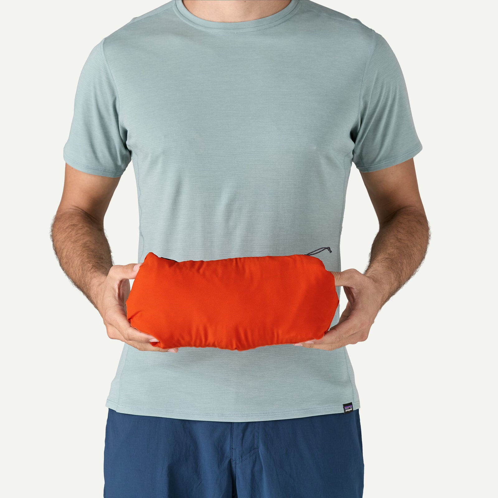 Patagonia Men's Nano-Air® Ultralight Pullover in color pollinator orange (just as example), heldby model, showcasing the packability