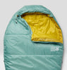 A mint green sleeping bag with a bright yellow interior lining, shown from a top-down view on a light gray background. The brand 'Mountain Hard Wear' is printed on the lower right, and 'Alpine' is visible on the inner collar.