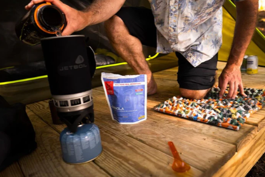someone using the nemo chipper pad for their knee while making a meal