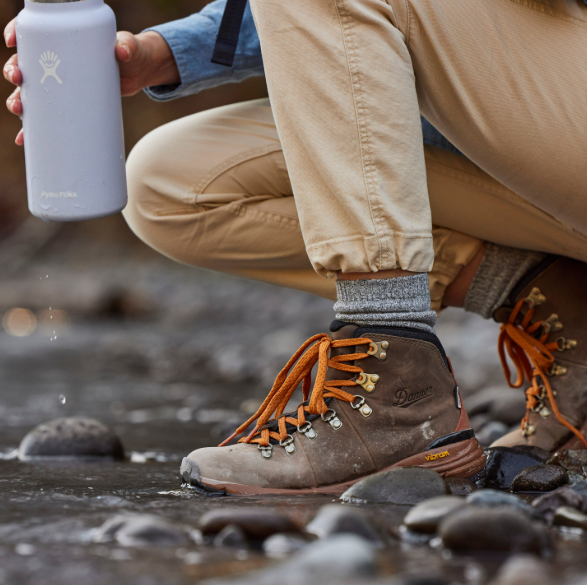 danner womens mountain 600 wide width color chocolate chip worn by a model in a stream