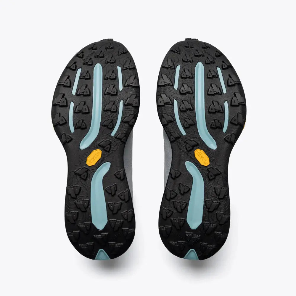 Black and blue sole of a shoe with a yellow dot on a white background