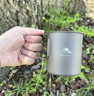 a hand holding the toaks ultralight titanium 450 mug