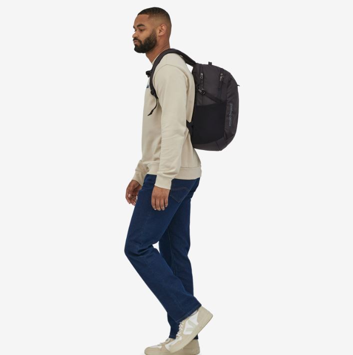 a photo of the patagonia refugio daypack 26 litres in the color black, back view on a model