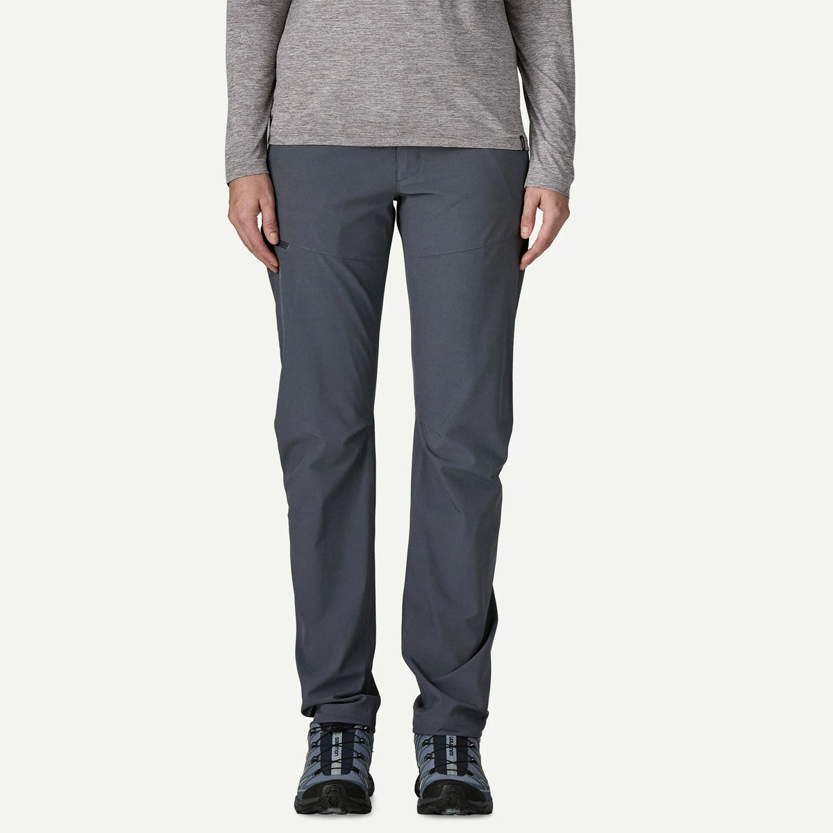 Person wearing gray pants and a long-sleeve shirt on a white background