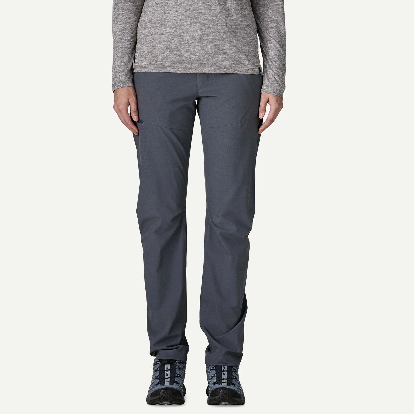 Person wearing gray pants and a long-sleeve shirt on a white background
