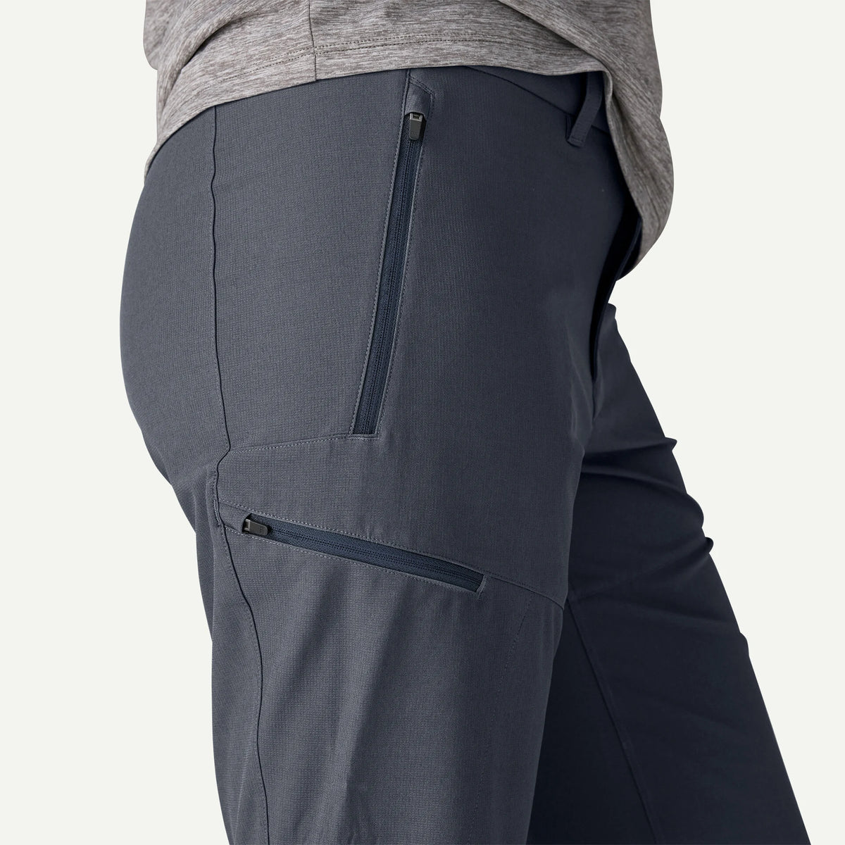 Dark gray pants with zippers on a light gray background