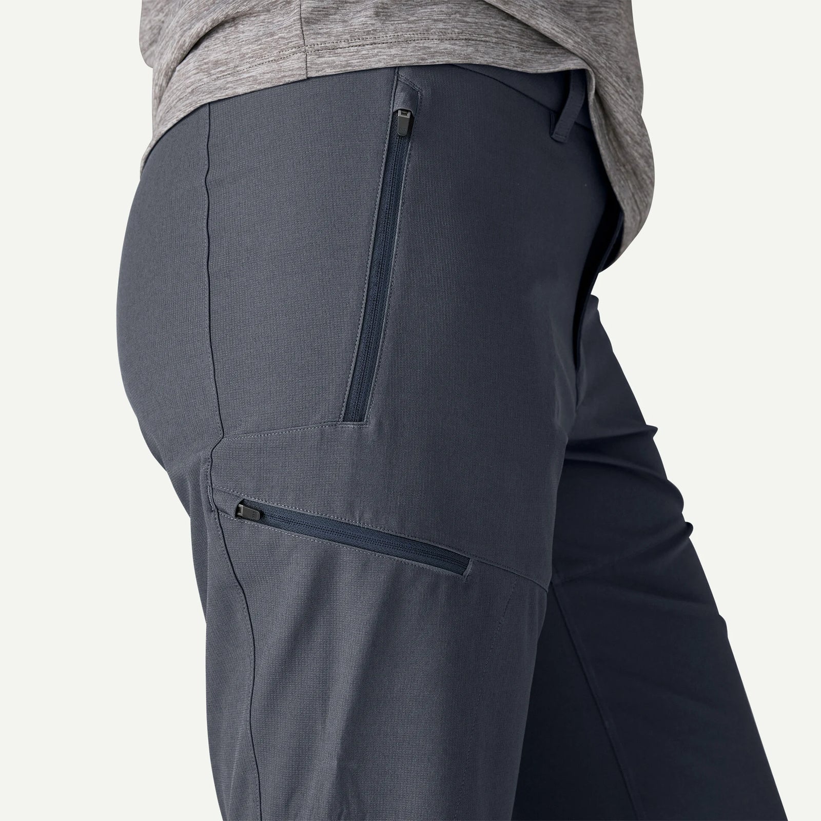 Dark gray pants with zippers on a light gray background