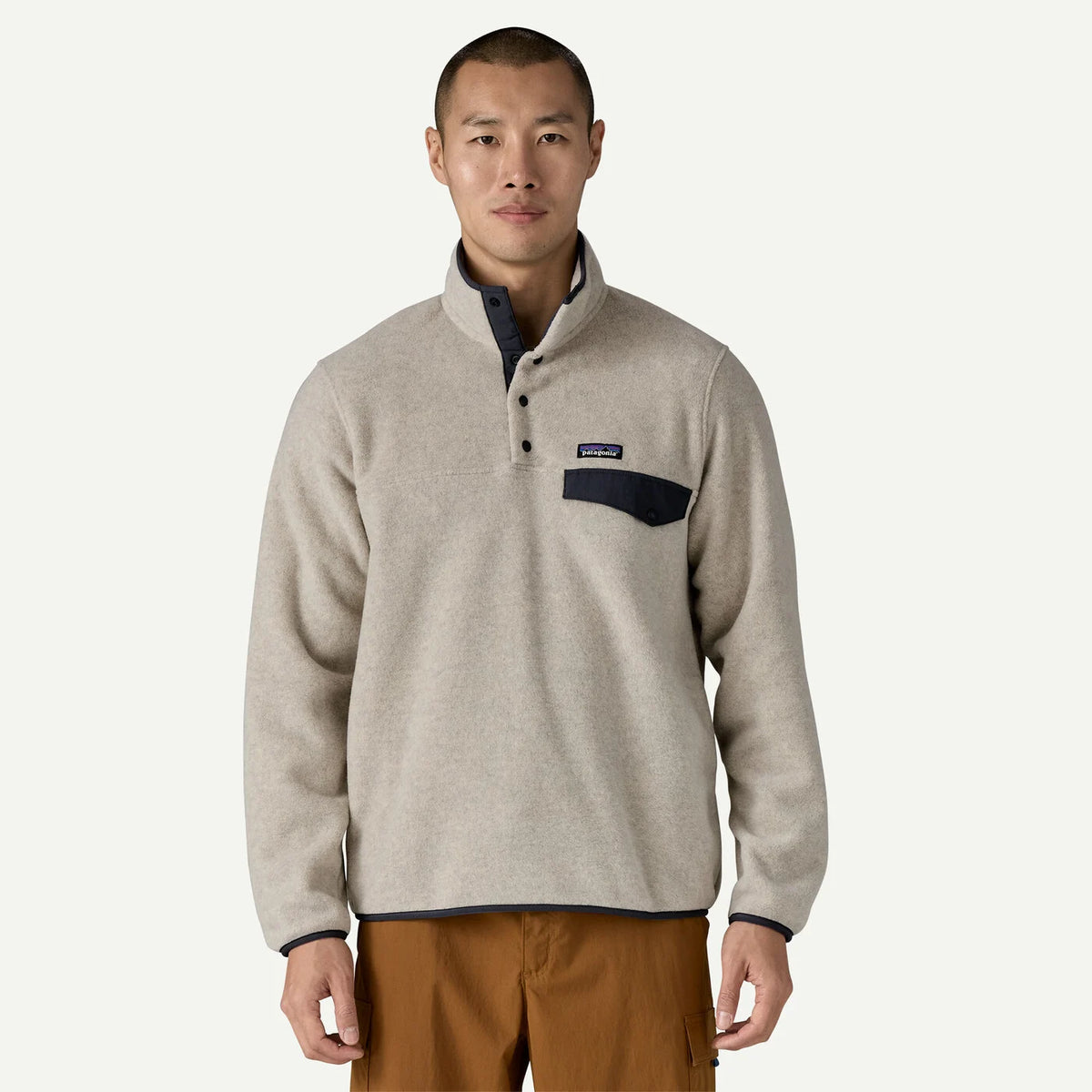 Man wearing a beige fleece pullover with a logo on a white background
