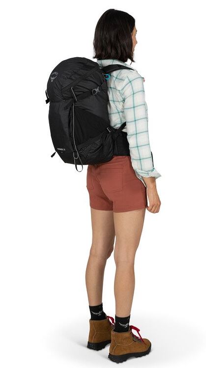 a photo of the osprey skimmer 28 backpack in the color black, back view on a model
