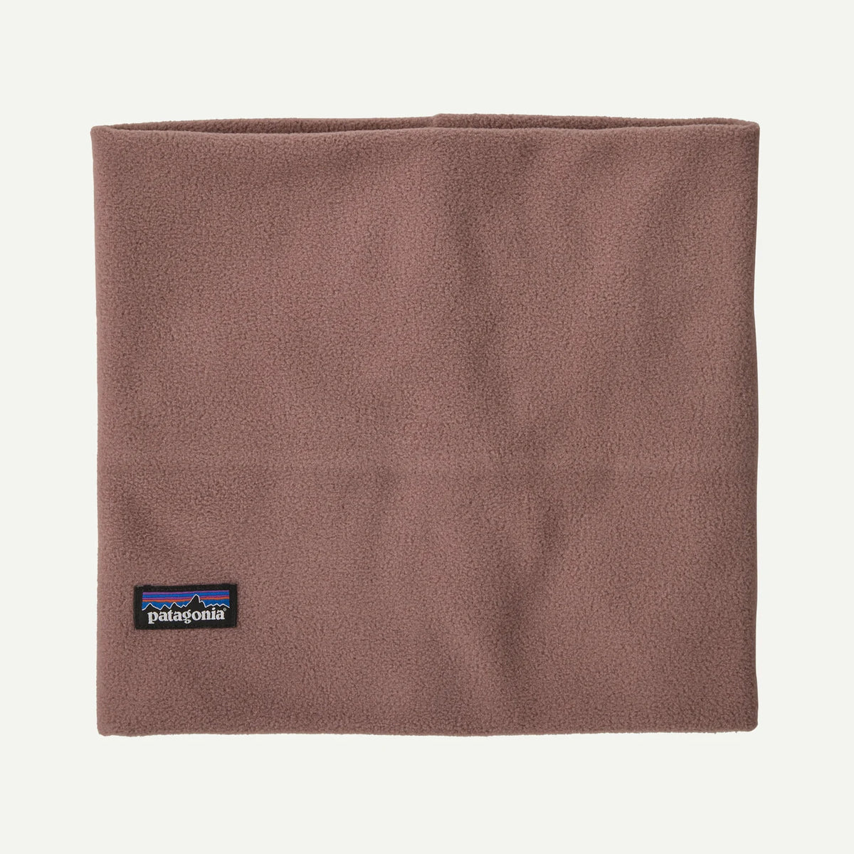 A Patagonia fleece neck gaiter in a dusty rose-brown color, featuring the signature black and multicolor Patagonia logo patch near the bottom left corner, set against a clean off-white background.