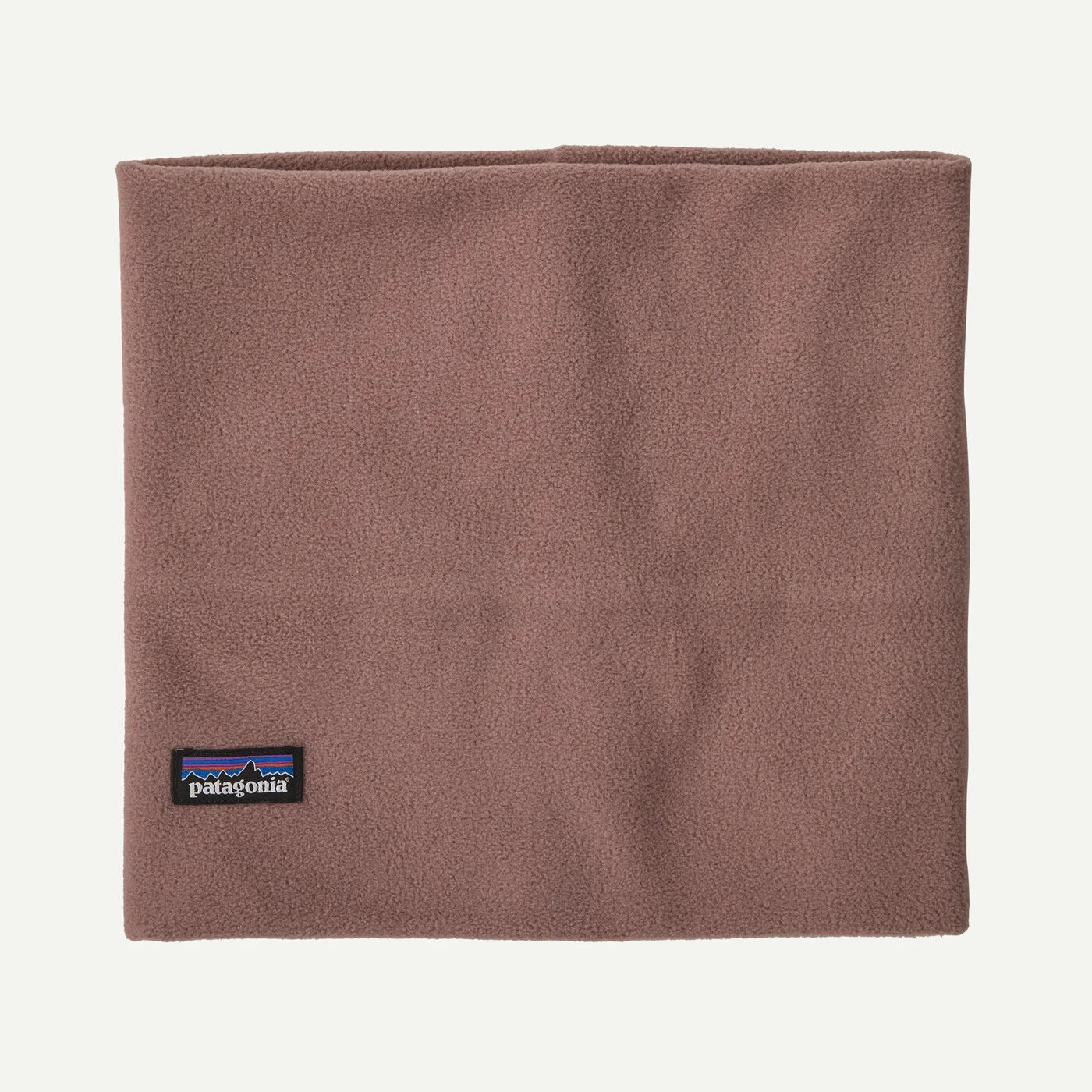 A Patagonia fleece neck gaiter in a dusty rose-brown color, featuring the signature black and multicolor Patagonia logo patch near the bottom left corner, set against a clean off-white background.