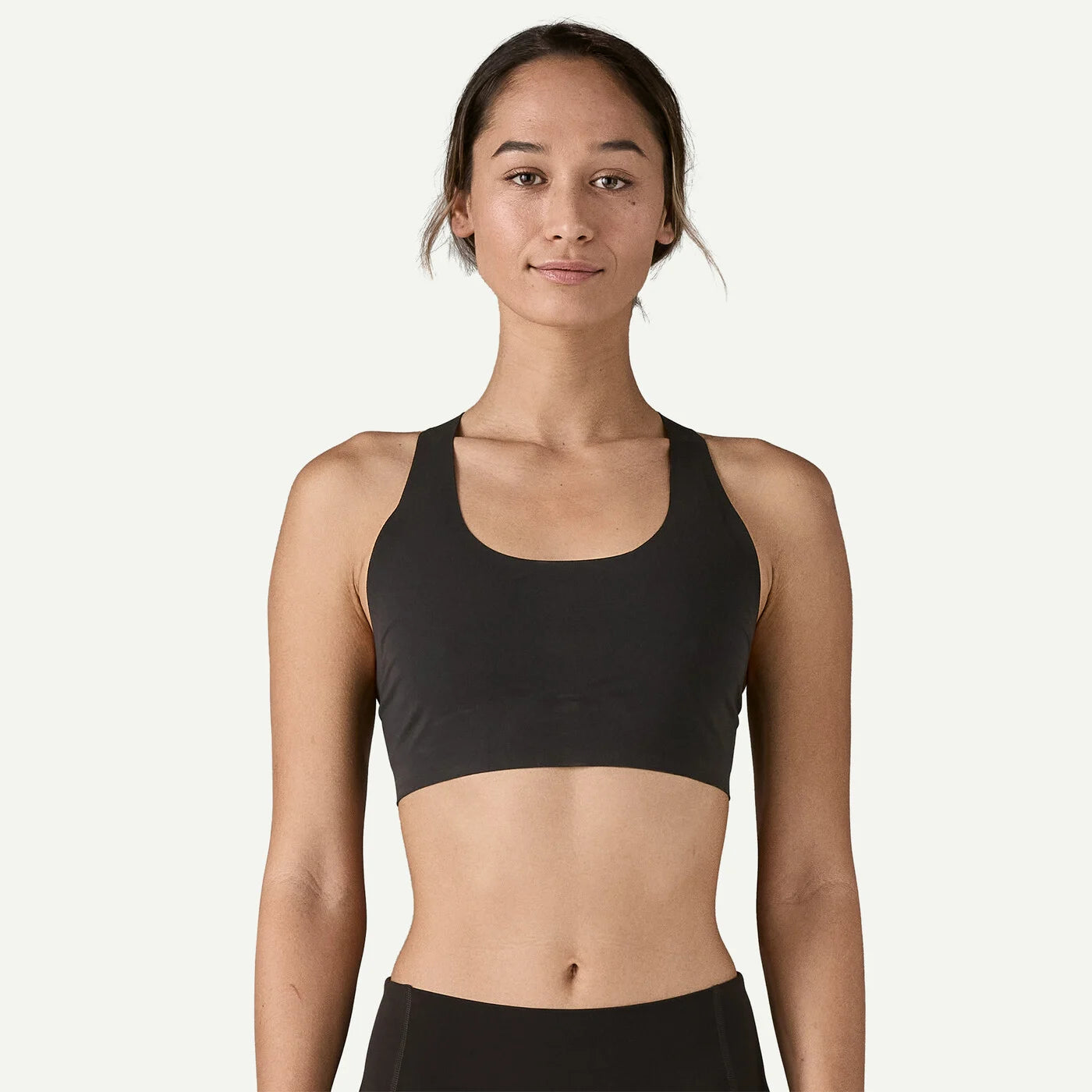 Woman wearing a black sports bra on a white background