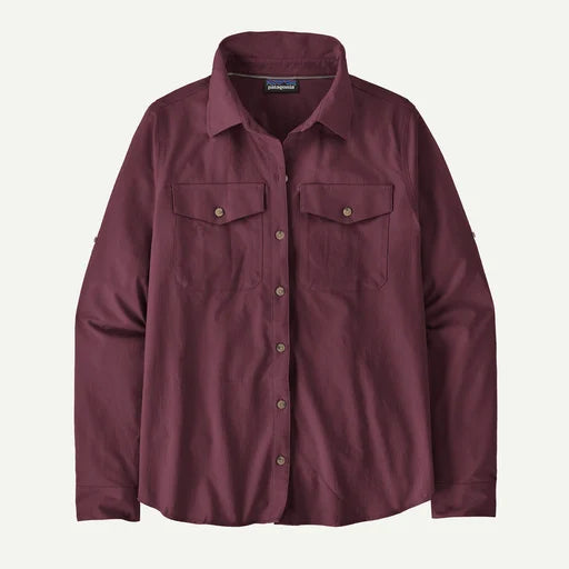 A Patagonia women's long-sleeve button-up shirt in a deep burgundy color, featuring two buttoned chest pockets and a classic collar, shown against a light off-white background.