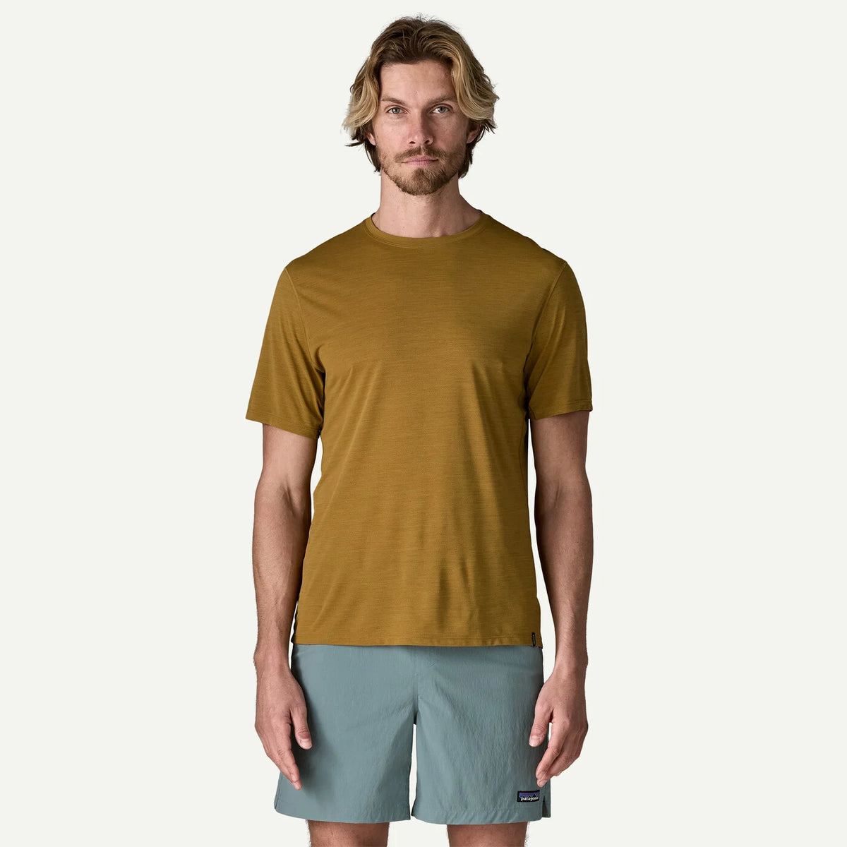 Man wearing a Golden t-shirt and light gray shorts on a white background