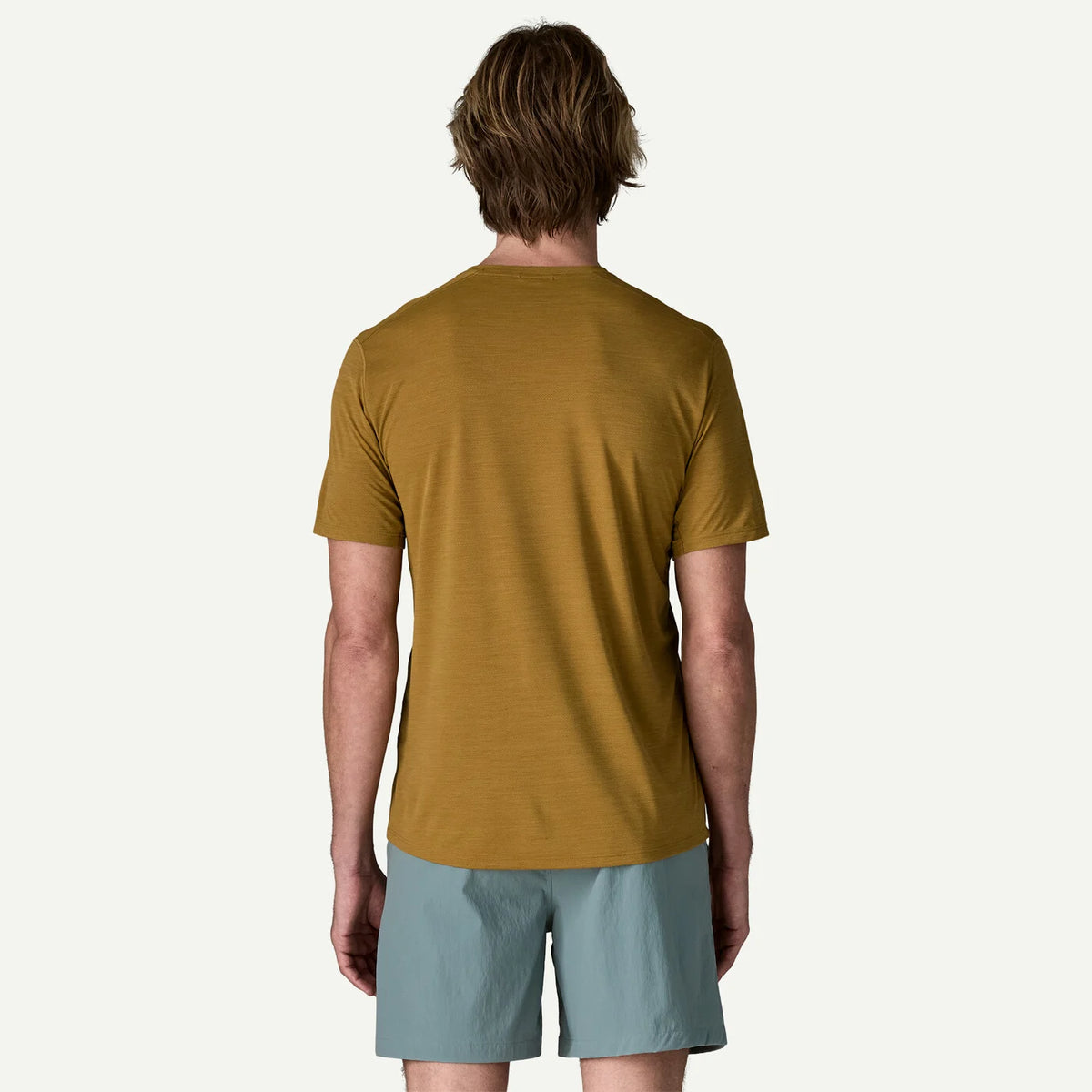 Person wearing a Golden t-shirt and light blue shorts on a white background