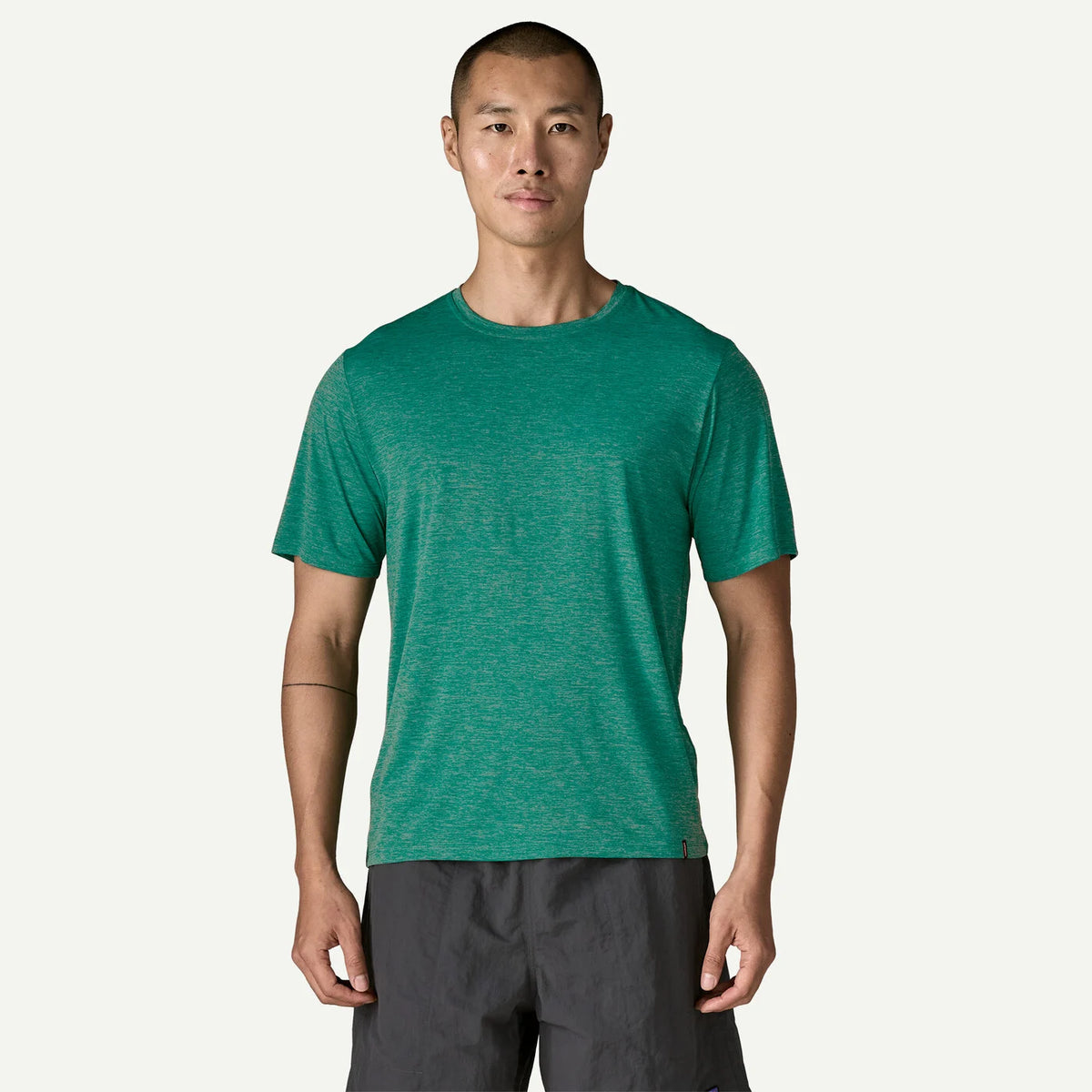 Man wearing a green t-shirt and black pants on a white background