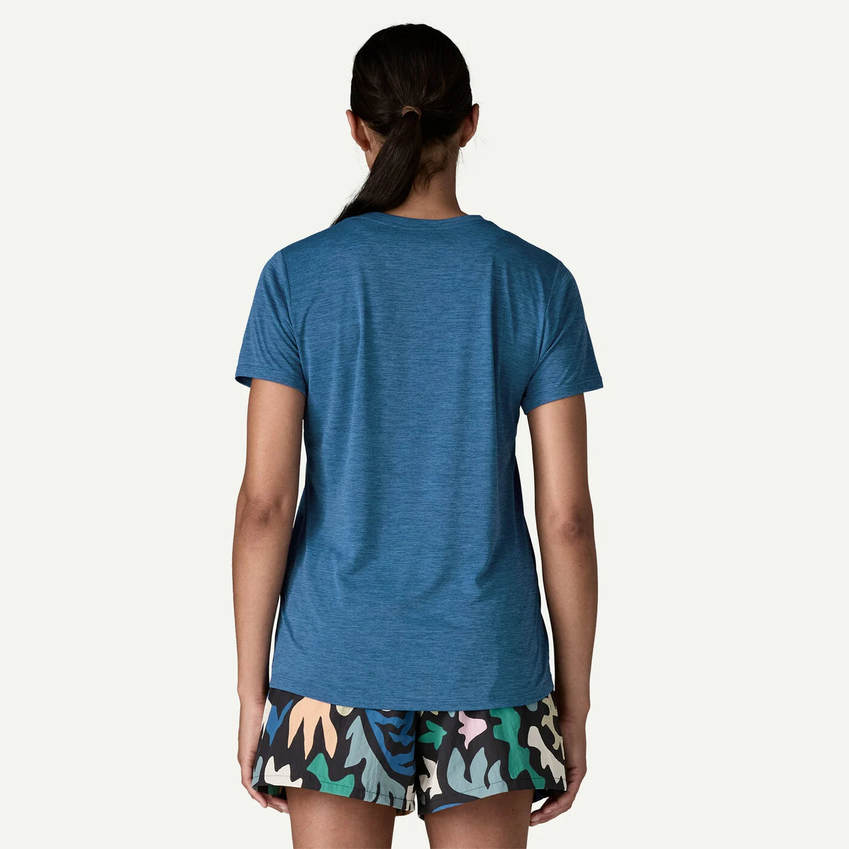 Person wearing a blue t-shirt and colorful shorts on a white background
