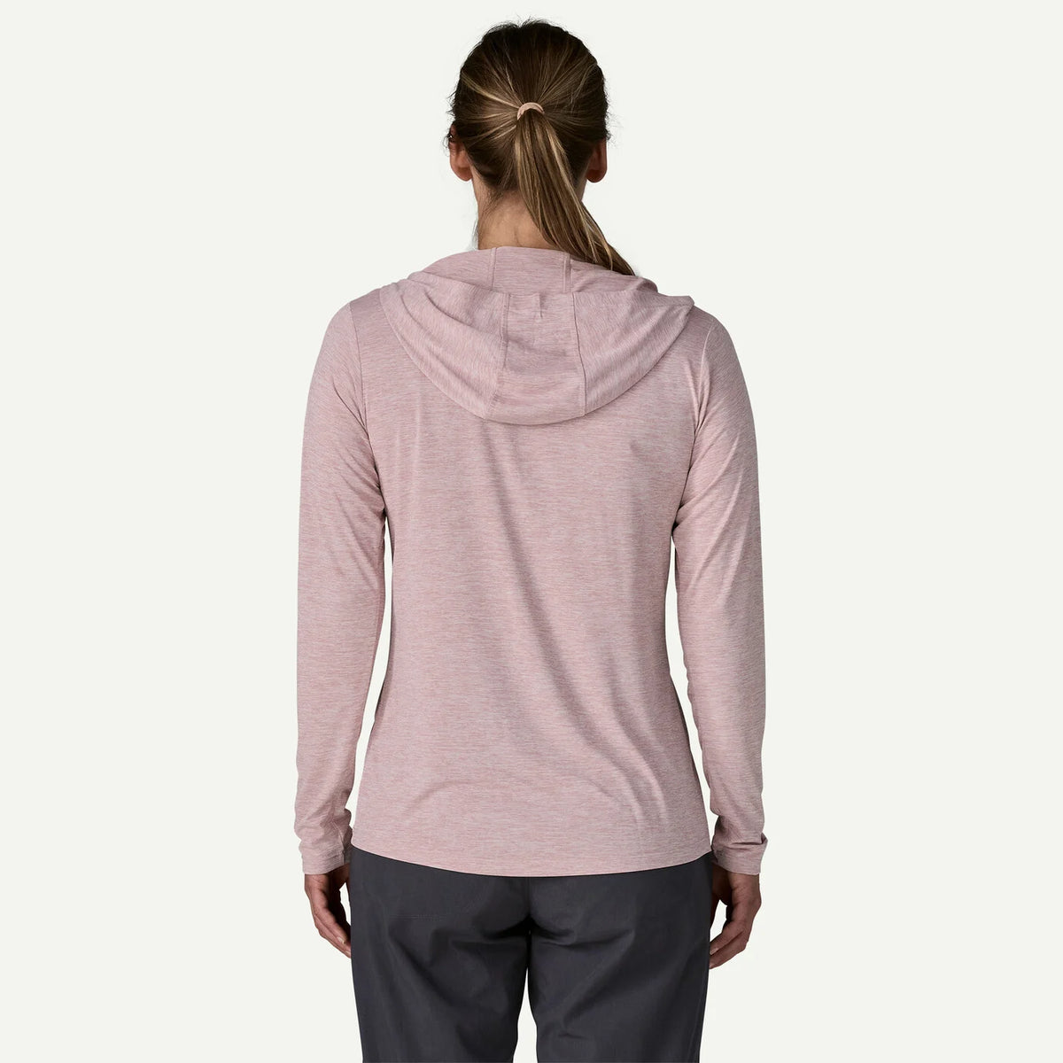 Person wearing a light pink hoodie on a white background