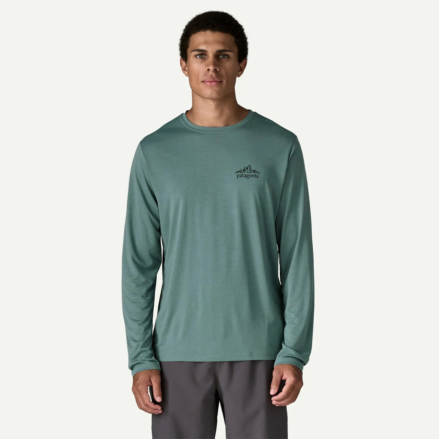 Man wearing a green long-sleeve shirt with a logo on a white background