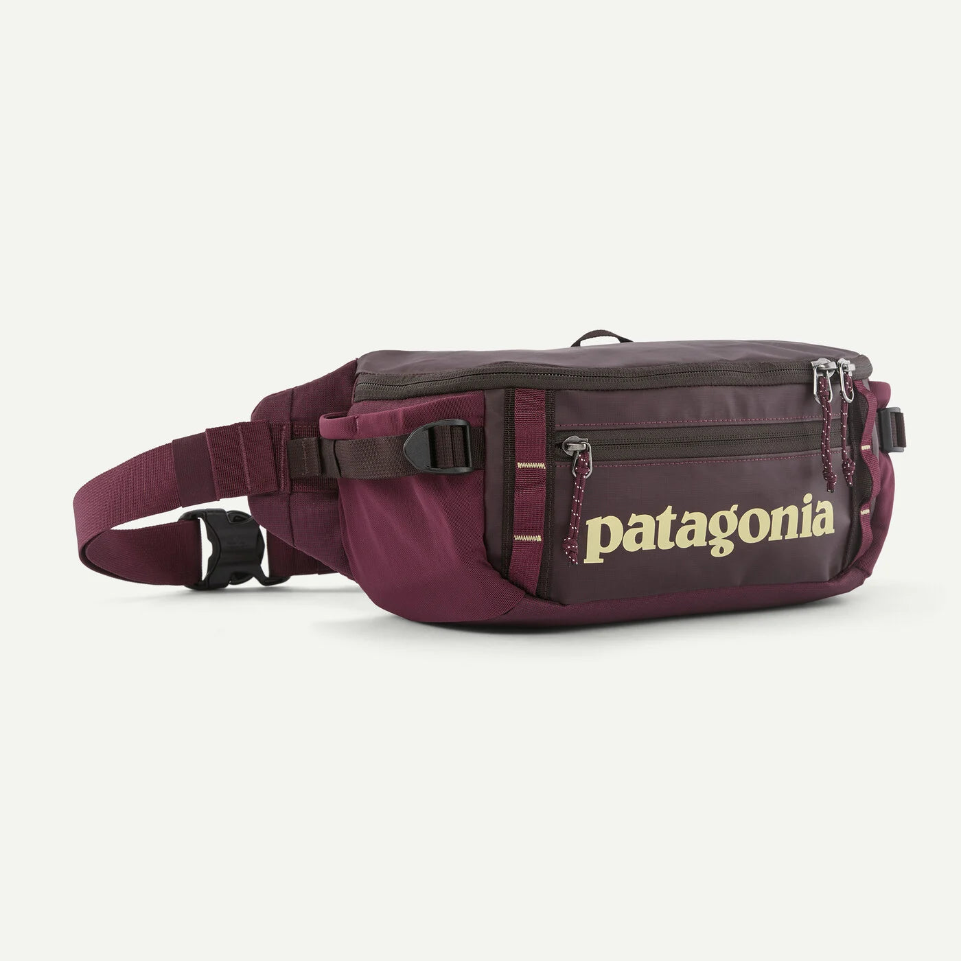 A Patagonia waist bag in burgundy with a dark brown front pocket featuring the gold Patagonia logo, shown on a clean white background.