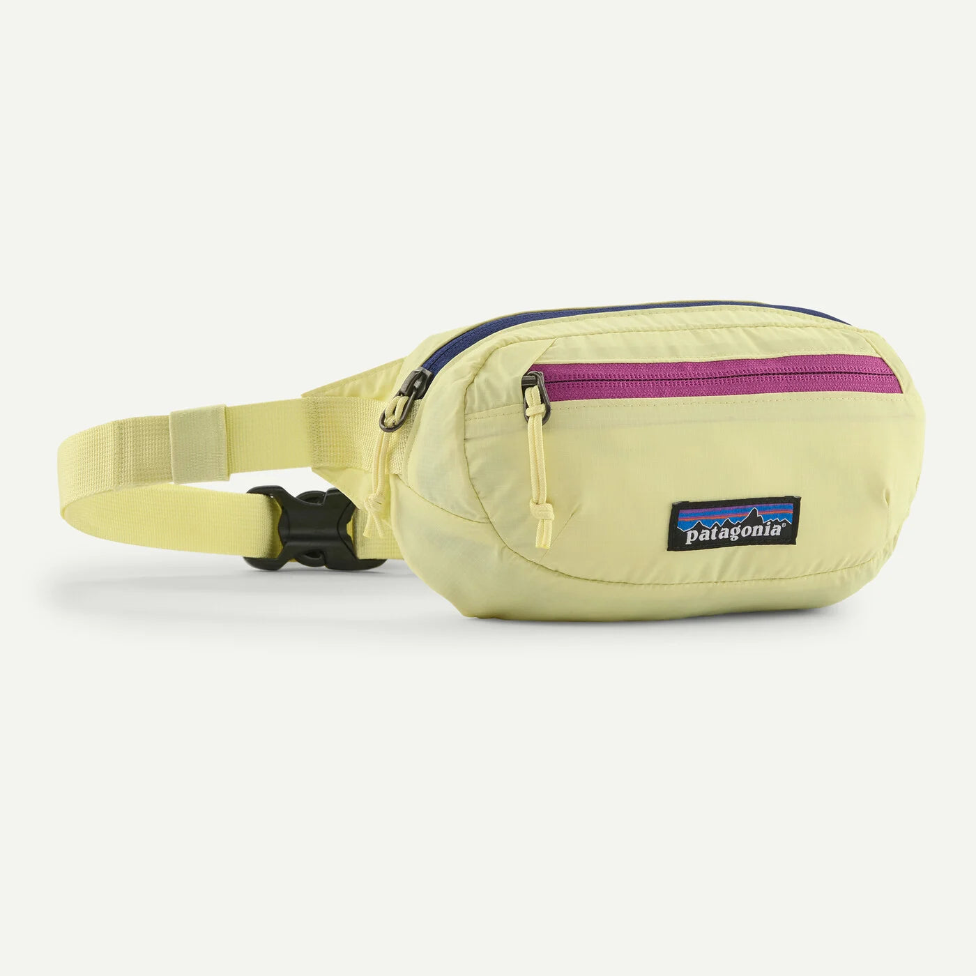 A light yellow Patagonia waist bag with a purple zipper accent and a black buckle, shown on a clean off-white background.