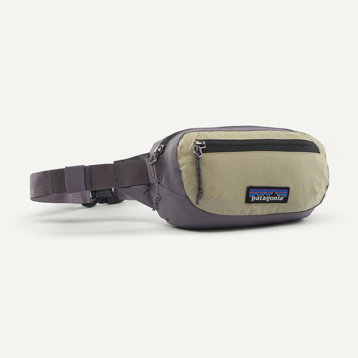 A Patagonia waist bag in a muted sage green and dark gray colorway, featuring a front zippered pocket and an adjustable waist strap, shown on a light gray background.