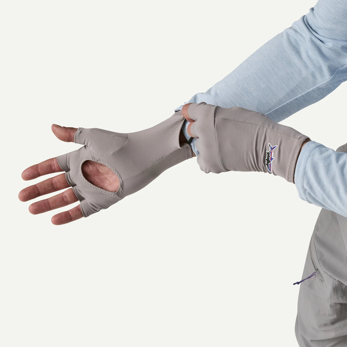 Person wearing a gray fingerless glove on a white background