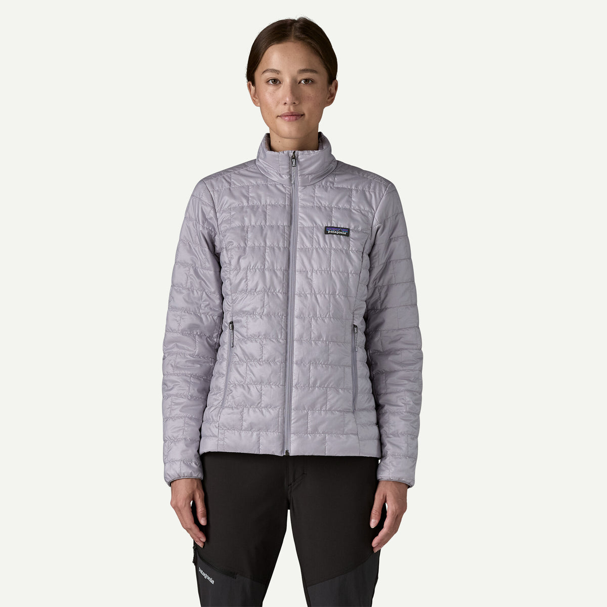 Person wearing a light purple insulated jacket with a visible Patagonia logo on a white background