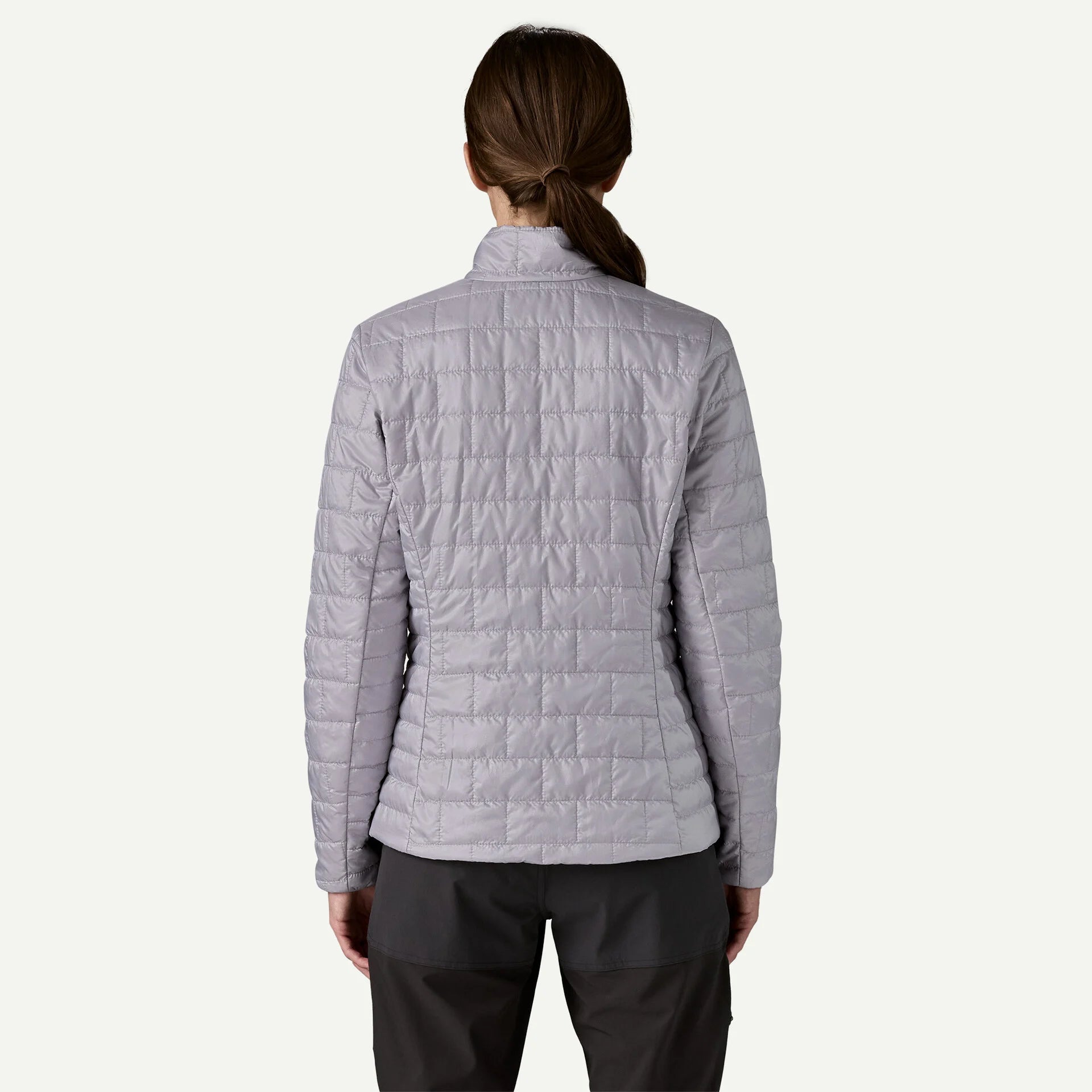 Person wearing a light purple quilted jacket on a white background