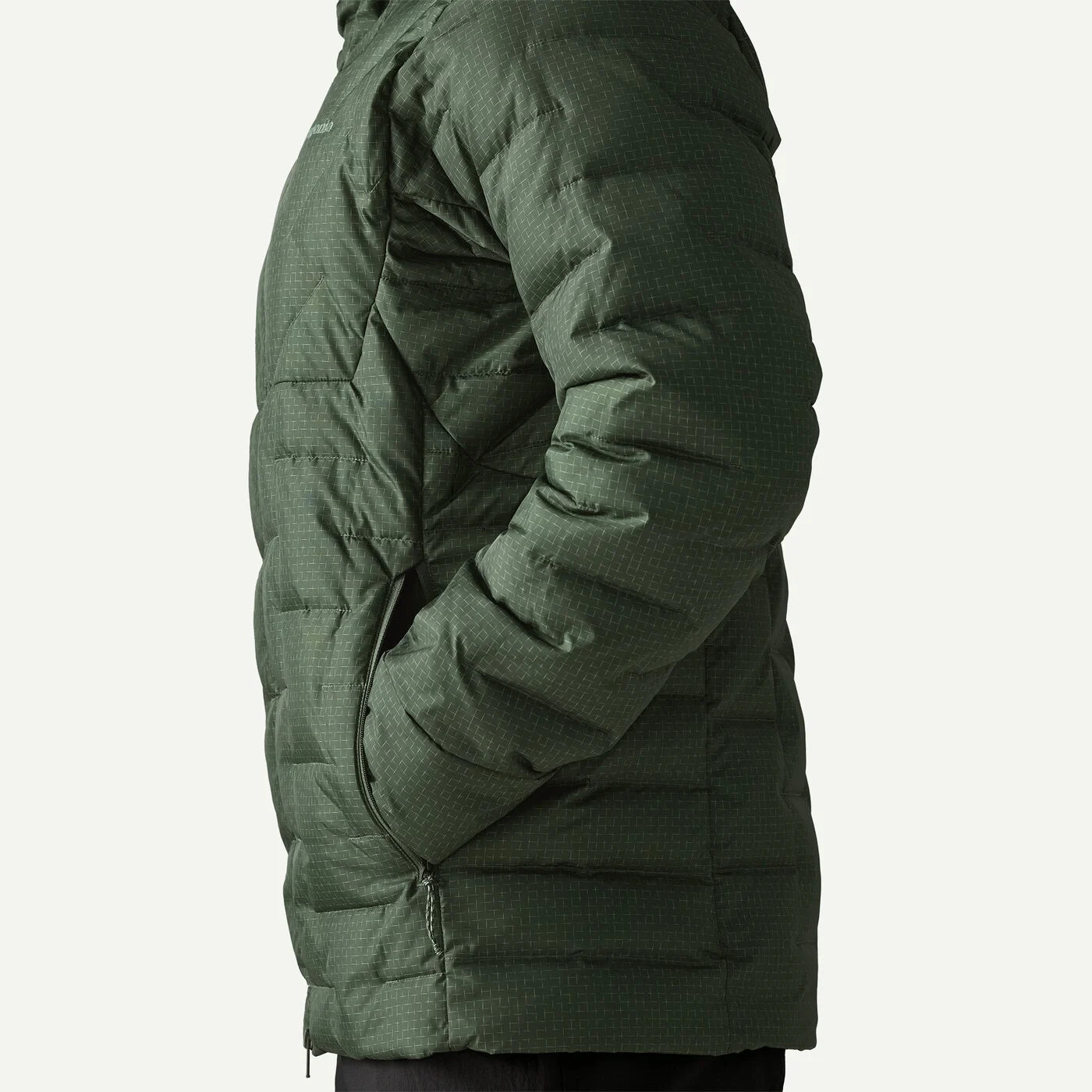 Side view of a dark green quilted puffer jacket on a white background.