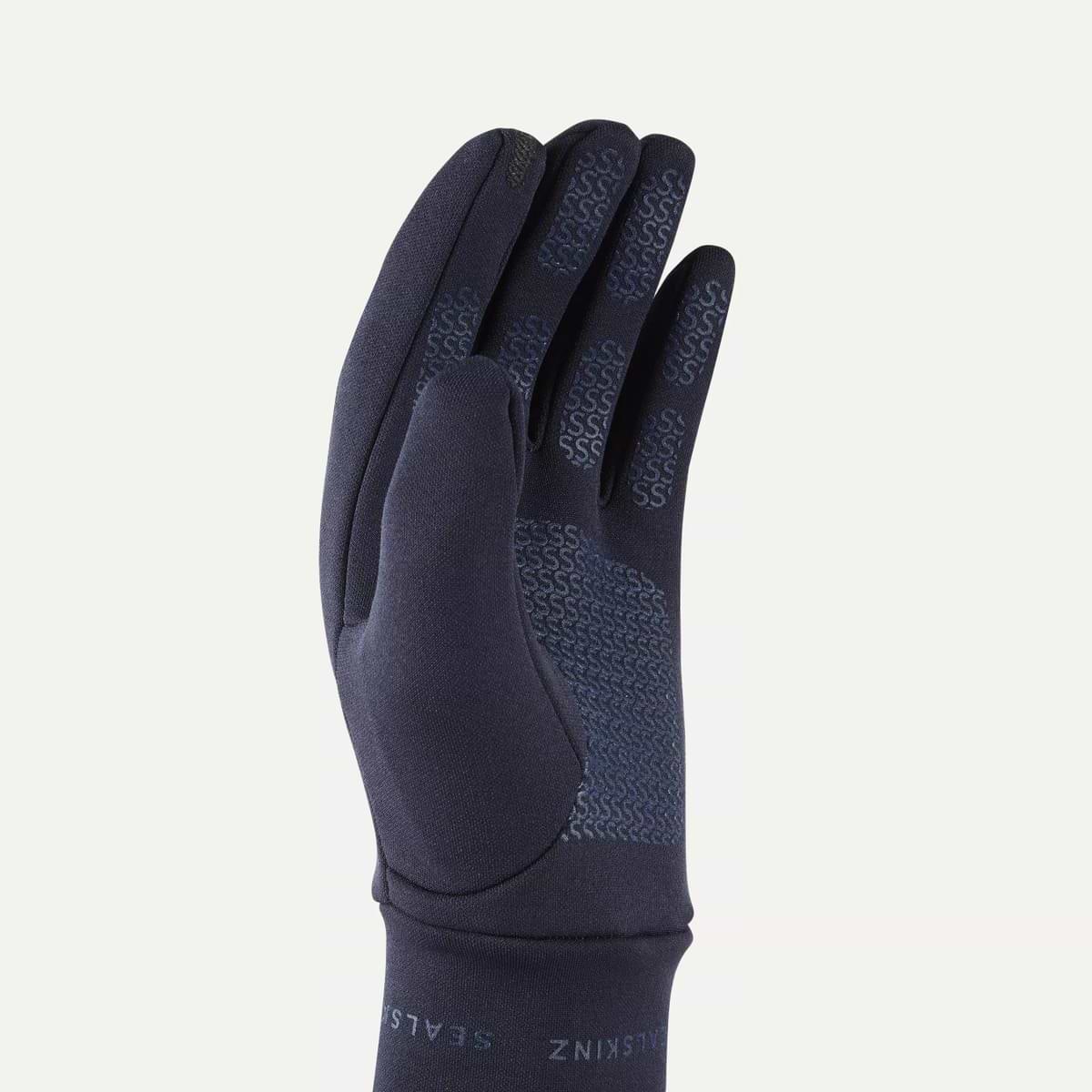 A single dark navy blue glove shown from the back, featuring textured grip patterns on the back of the fingers and palm, with the brand name 'Sealskinz' visible on the cuff, set against a plain white background.