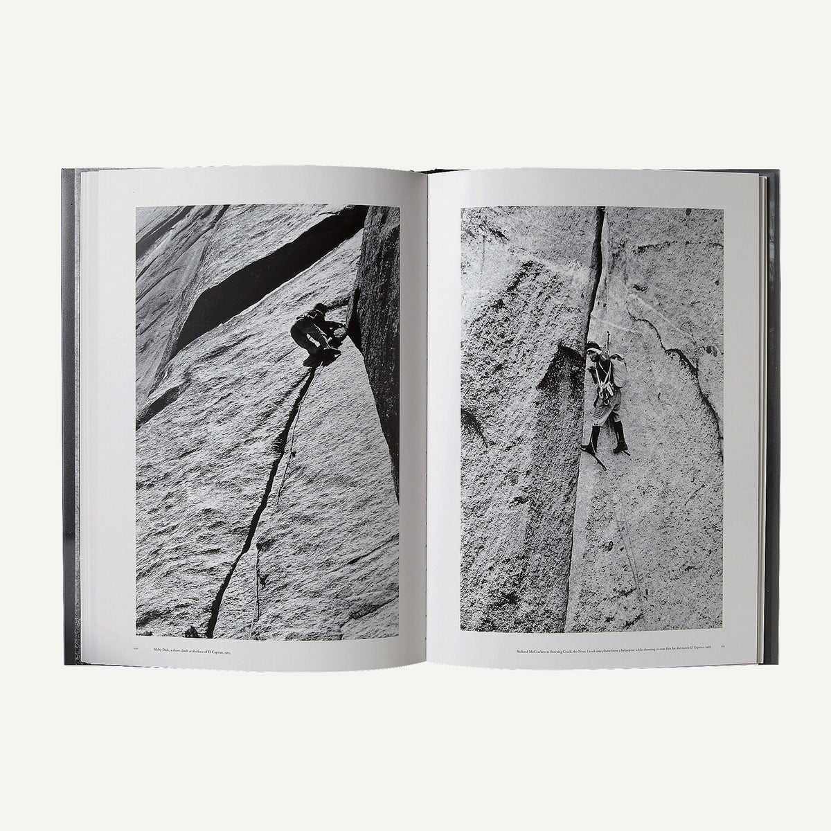 An open hardcover book showing two black-and-white photographic pages of a rock climber on a steep cliff face, photographed against a light gray background.