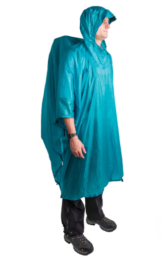 A man wearing a shiny teal-green hooded rain poncho, black pants, and black boots, shown in profile against a plain white background.