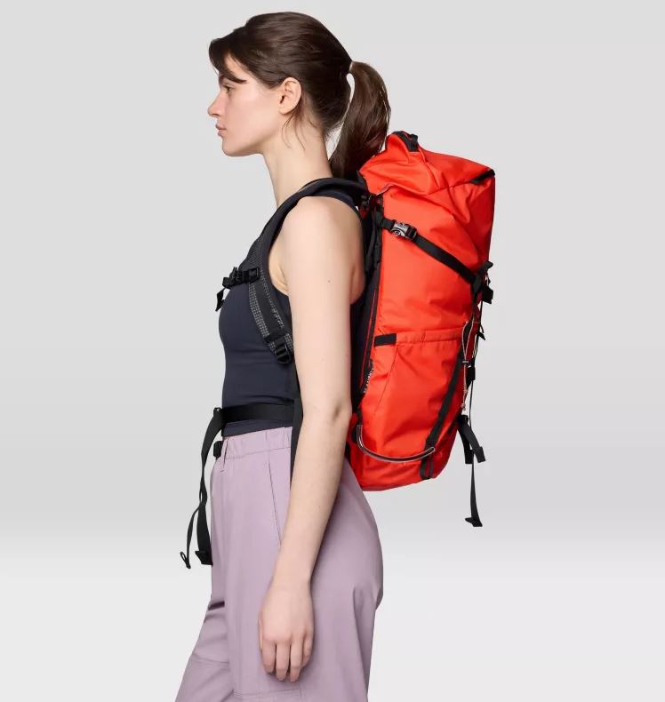 Mountain Hardwear Scrambler 25 Backpack, in state orange, worn by model, side view