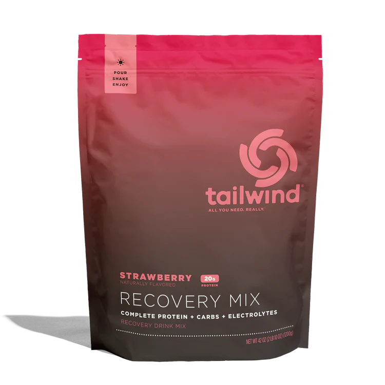 A stand-up pouch of Tailwind Recovery Mix in Strawberry flavor, featuring a dark brown to bright pink gradient design with white and pink text, photographed on a white background with a soft shadow.
