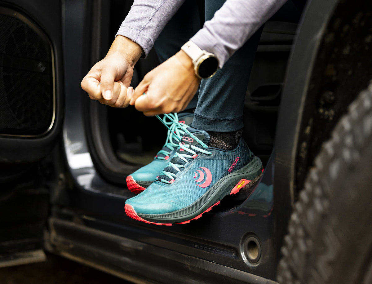 a person lacing up a pair of mt5's 