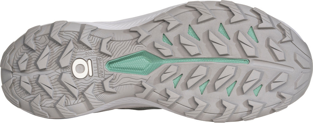 Close-up of a gray and green athletic shoe sole with brand logo.