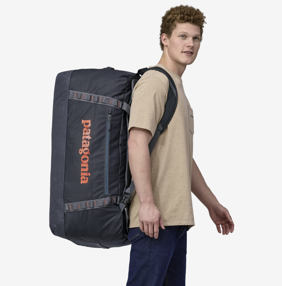 the patagonia black hole duffel in color smolder blue, shown with a model
