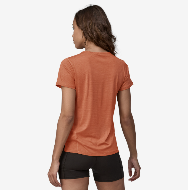 the patagonia womens short sleeve capilene lightweight shirt in the color sienna clay, back view on a model