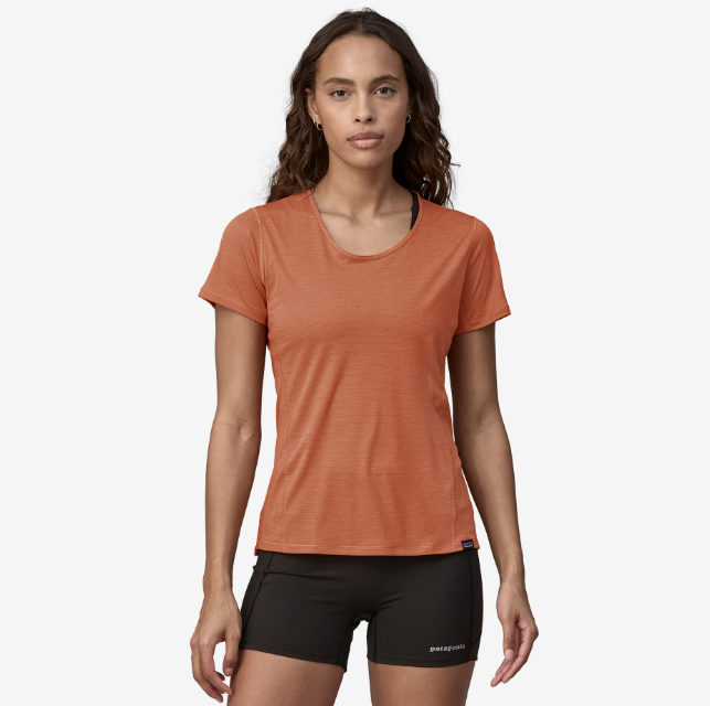 the patagonia womens short sleeve capilene lightweight shirt in the color sienna clay, front view on a model