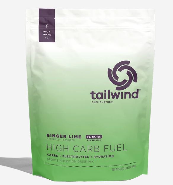 A stand-up pouch of tailwind High Carb Fuel drink mix in Ginger Lime flavor, featuring a white-to-light-green gradient design with a dark purple logo and text.