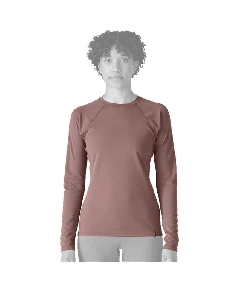 A woman wearing a fitted long-sleeve athletic top in a muted dusty rose or mauve color. The face area is obscured, and the lower body is cropped out.